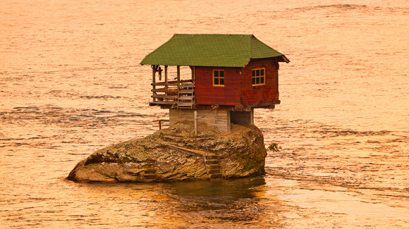 Openground House on rock island in river